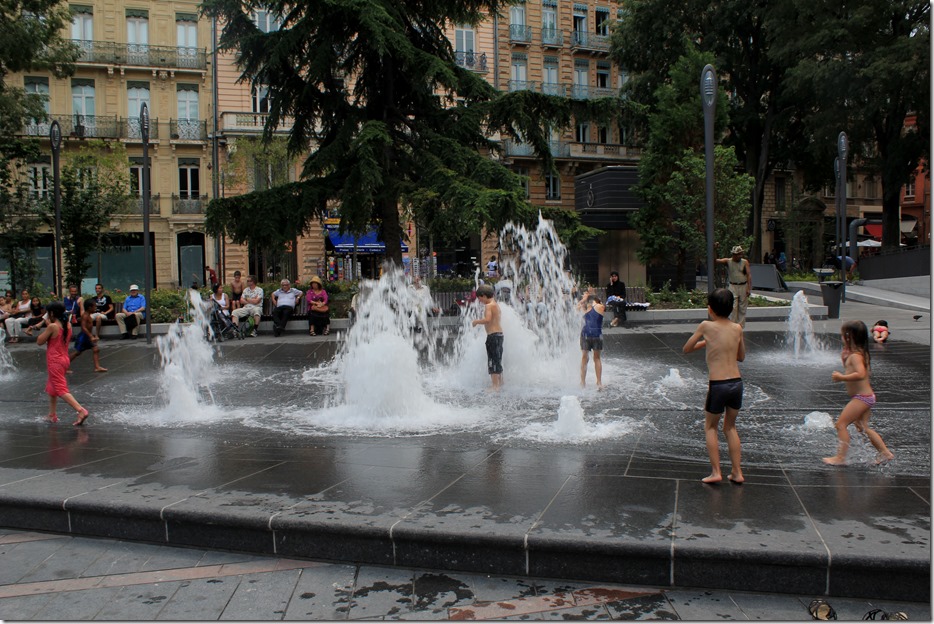 Children playing by the water fountains at the Capitolum